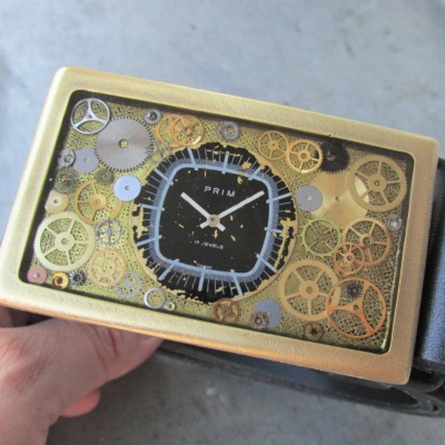 Originální černý opasek s číselníkem Prim Televize, bronzová spona z hodinek